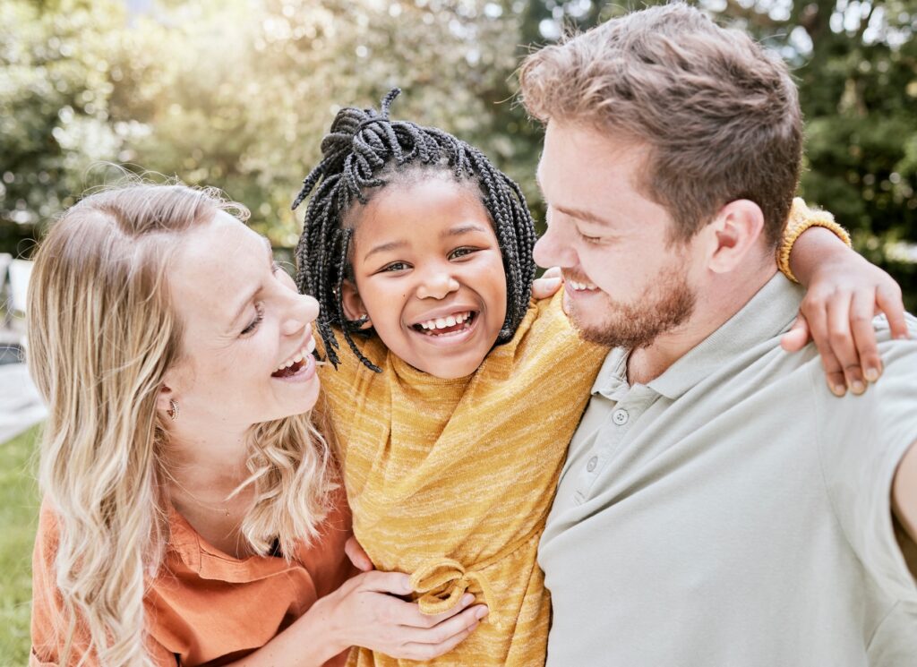 Happy parents with adopted daughter at park
