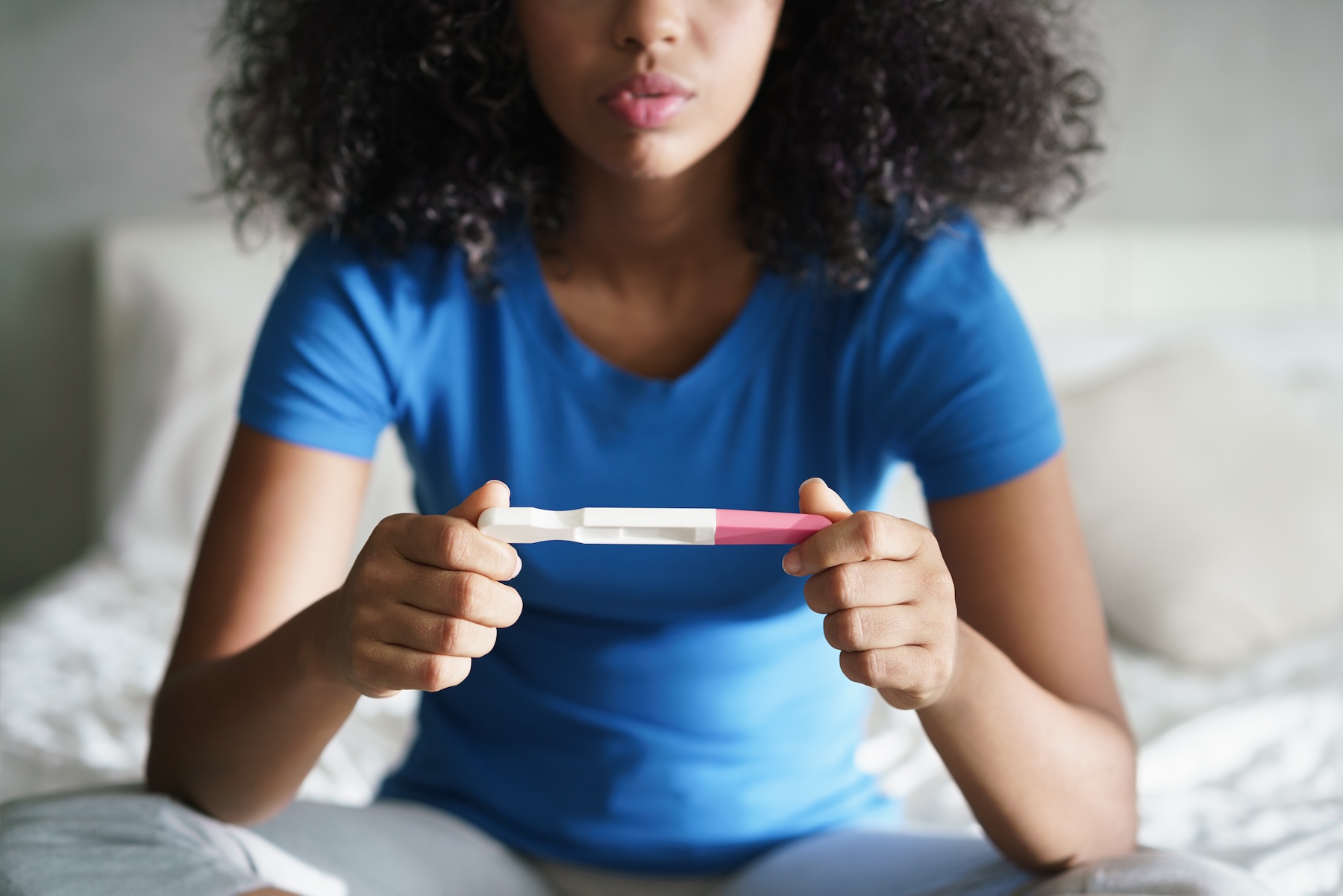 Woman taking pregnancy test and thinking about an adoption agency in Baton Rouge.