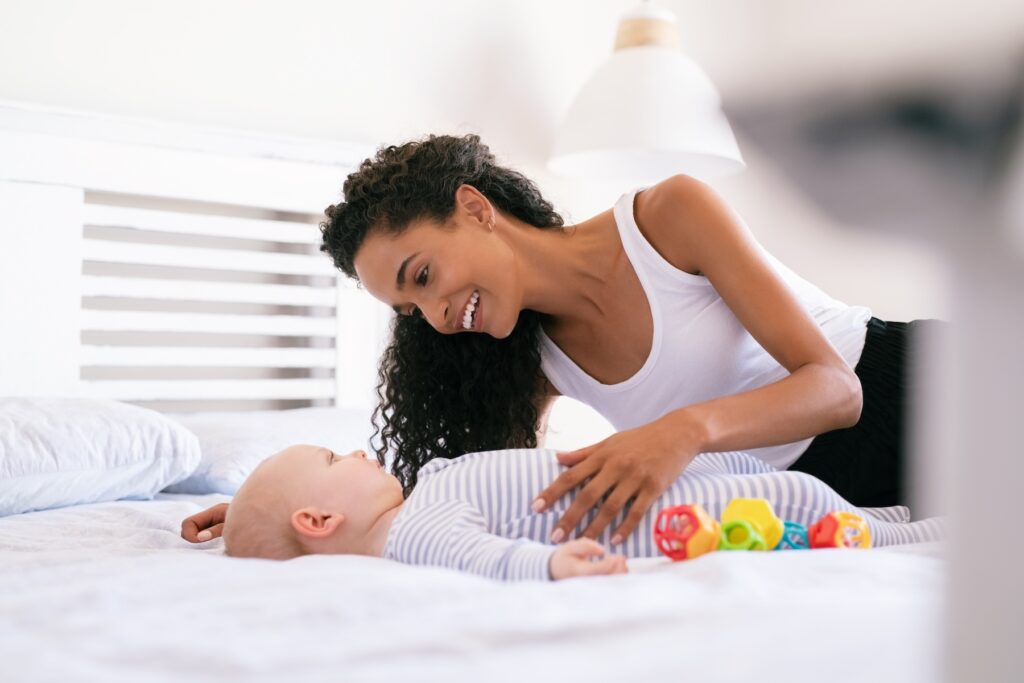 Mother and baby together on bed