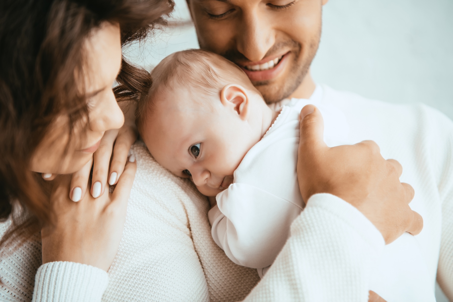 Happy man and wife holding baby